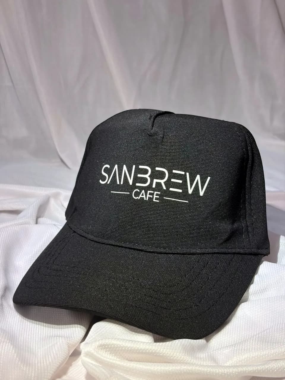 Black café cap with a white logo